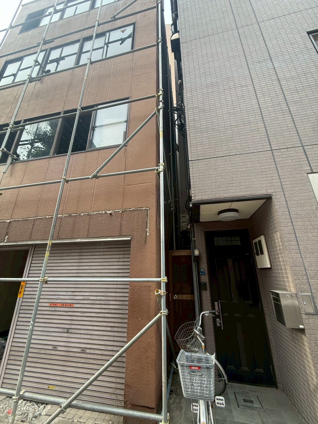 ビル解体工事に向けて鉄骨造ビルの外周に組まれた足場
